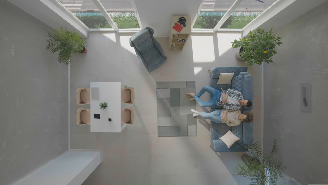 una joven pareja caucásica relajándose en el sofá.