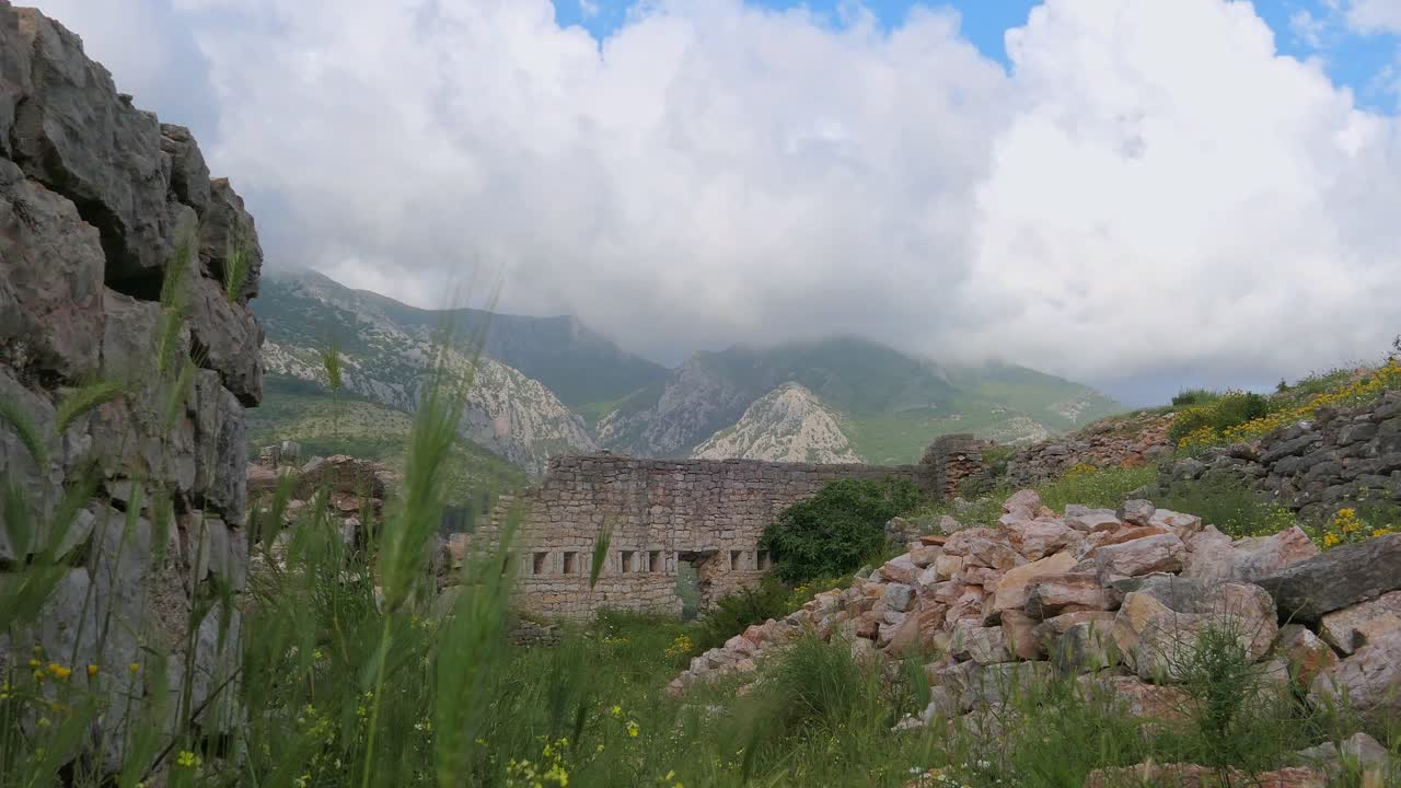 impresionante vista de la antigua fortaleza y las ruinas por las montañas con nubes dramáticas