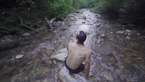 The-person-waving-his-wet-hair-in-the-stream.-Slow-motion.