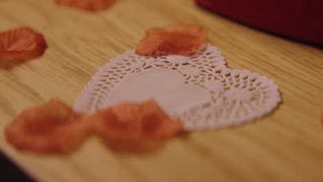 heart-shaped doily with rose petals