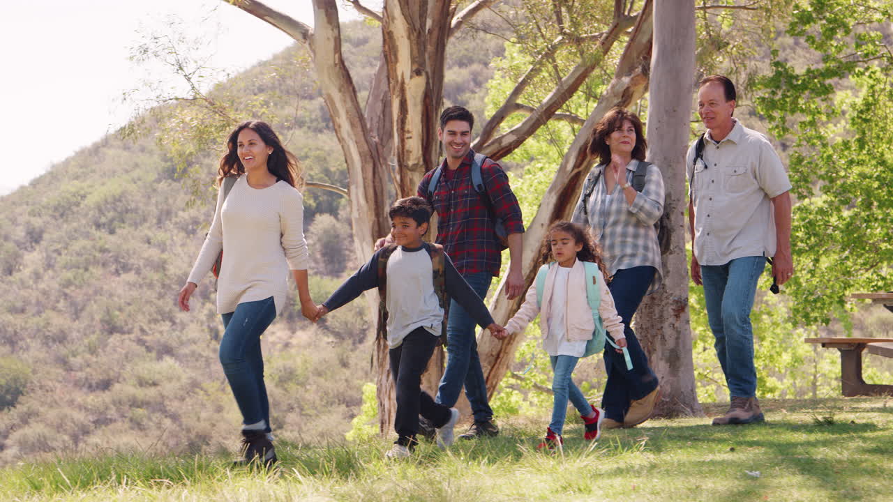 familia de varias generaciones caminando por un lago de montaña