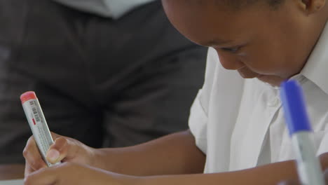 elementary schoolgirl writing at her desk, close up