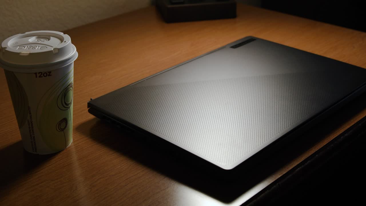 밝은 빛이 비추는 책상 위에 있는 노트북의 정적 샷