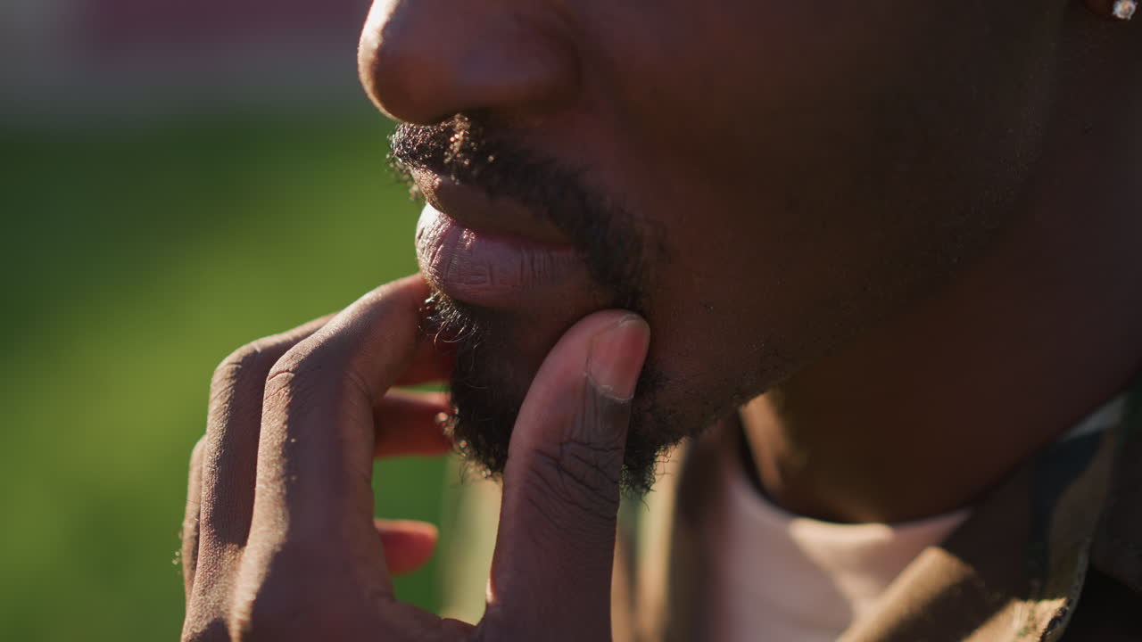 Man Outdoors Grooming, Closeup Of Man Grooming Outside, Close View Of Man Tending To Face In Sunlight Outdoors, Portrait Of Man Carefully Grooming His Face In Natural Outdoor Park Environment