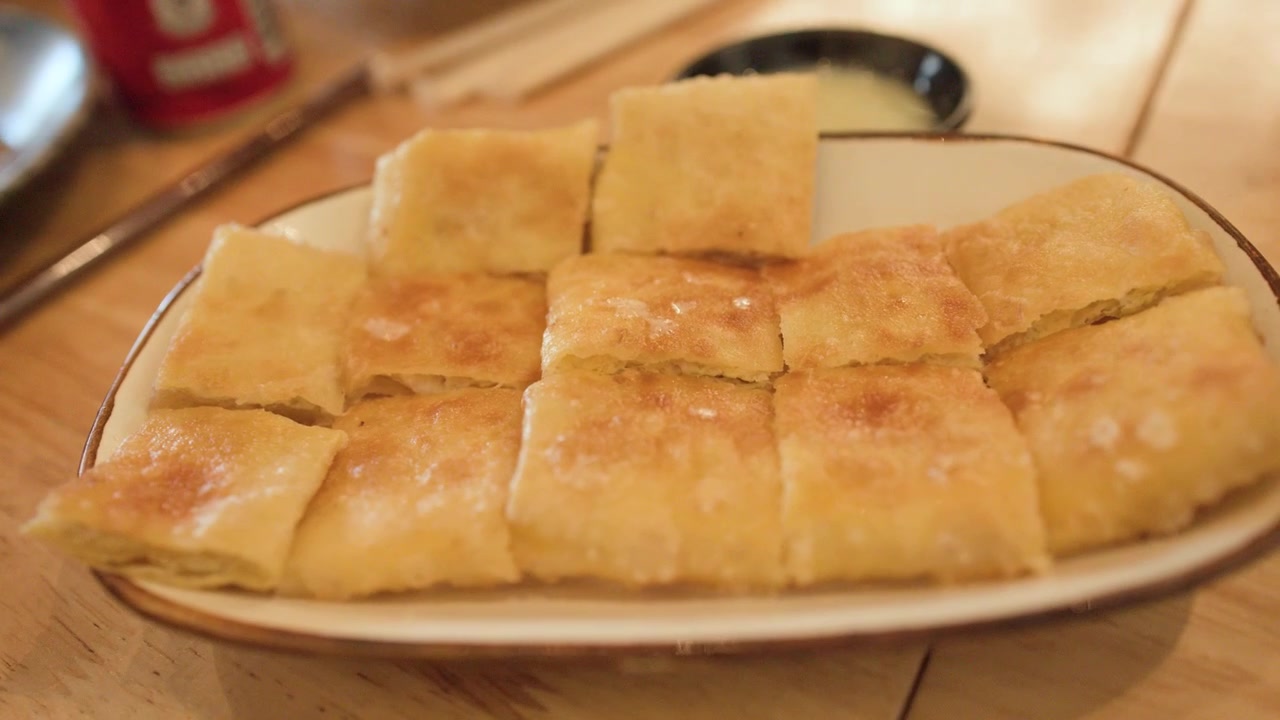 Primo piano di pezzi di roti dorati e fritti serviti su un piatto a Bangkok, Thailandia.