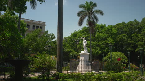 statue of a cuban hero on a clear day surrounded by vegetation in the plaza de armas in cuba