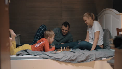 child setting his own rules during chess play with mom