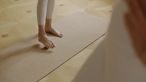 mujer practicando yoga en una alfombra