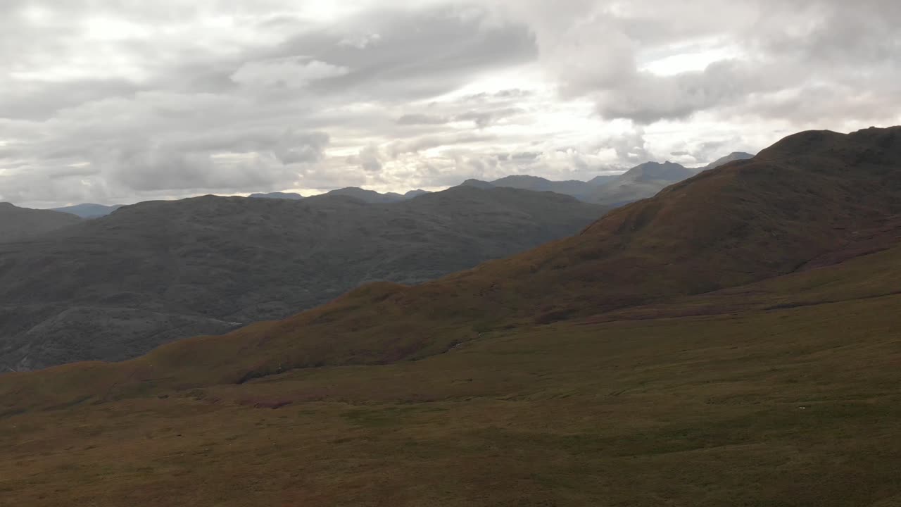 Scatto panoramico con drone di montagne con erba verde nel Parco Nazionale di Loch Lomond in Scozia