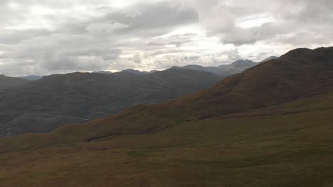 Panoramic-drone-shot-of-mountains-with-green-grass-in-loch-lomond-national-park-in-scotland