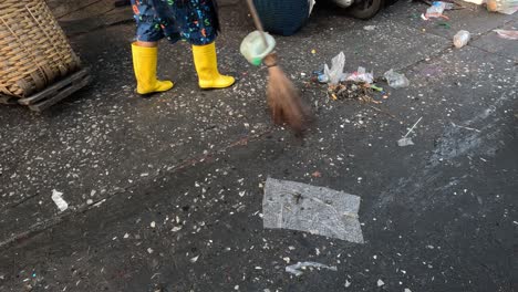 person sweeping litter off the street