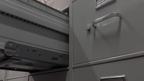 office worker closing a file cabinet in a file storage room