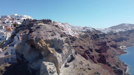 Pueblo-Griego-De-Oia,-Isla-De-Santorini,-Grecia.-Aéreo