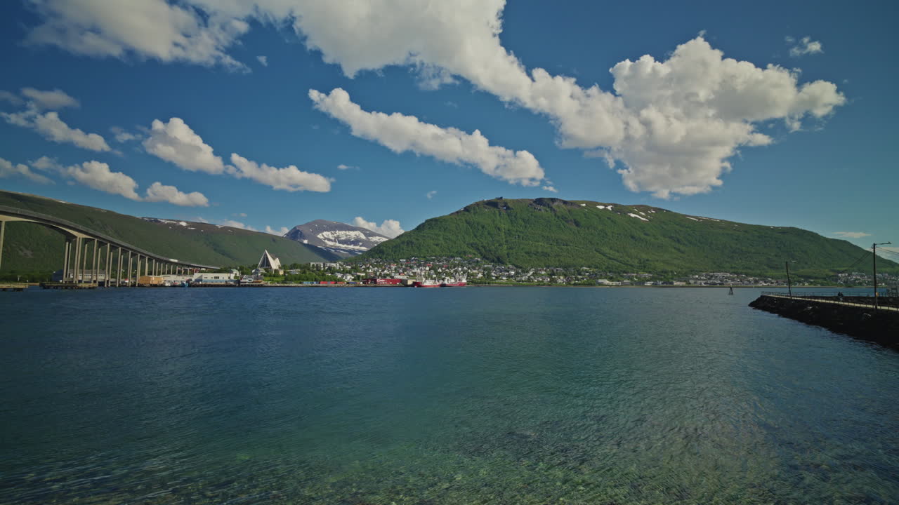 Panoramic view of the Norwegian Fjords in Tromso, Norway. View of the city, landscape sea and mountains. Bright blue sky with fluffy clouds.