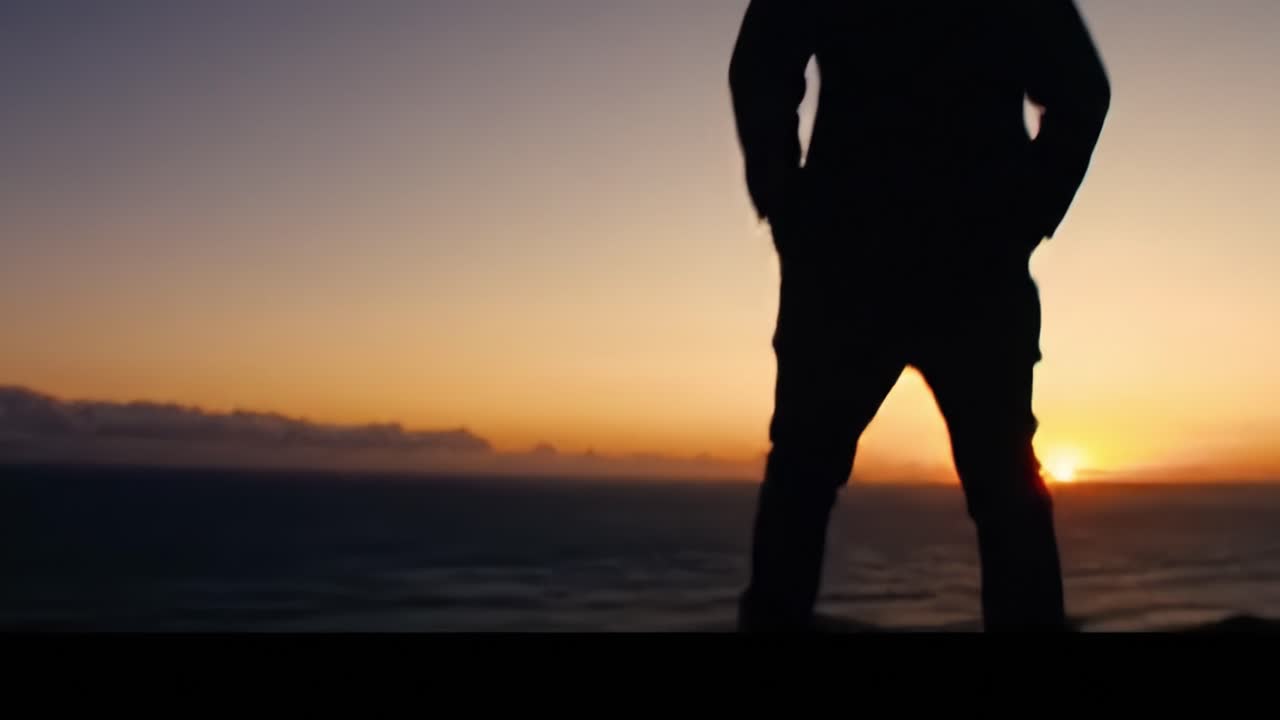 A Silhouetted Figure Stands at the Cliff's Edge During Golden Hour, Gazing at the Expansive Ocean and Stunning Sunset Landscape