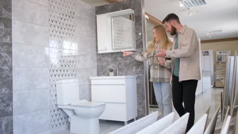 couple choosing bathroom tiles in showroom
