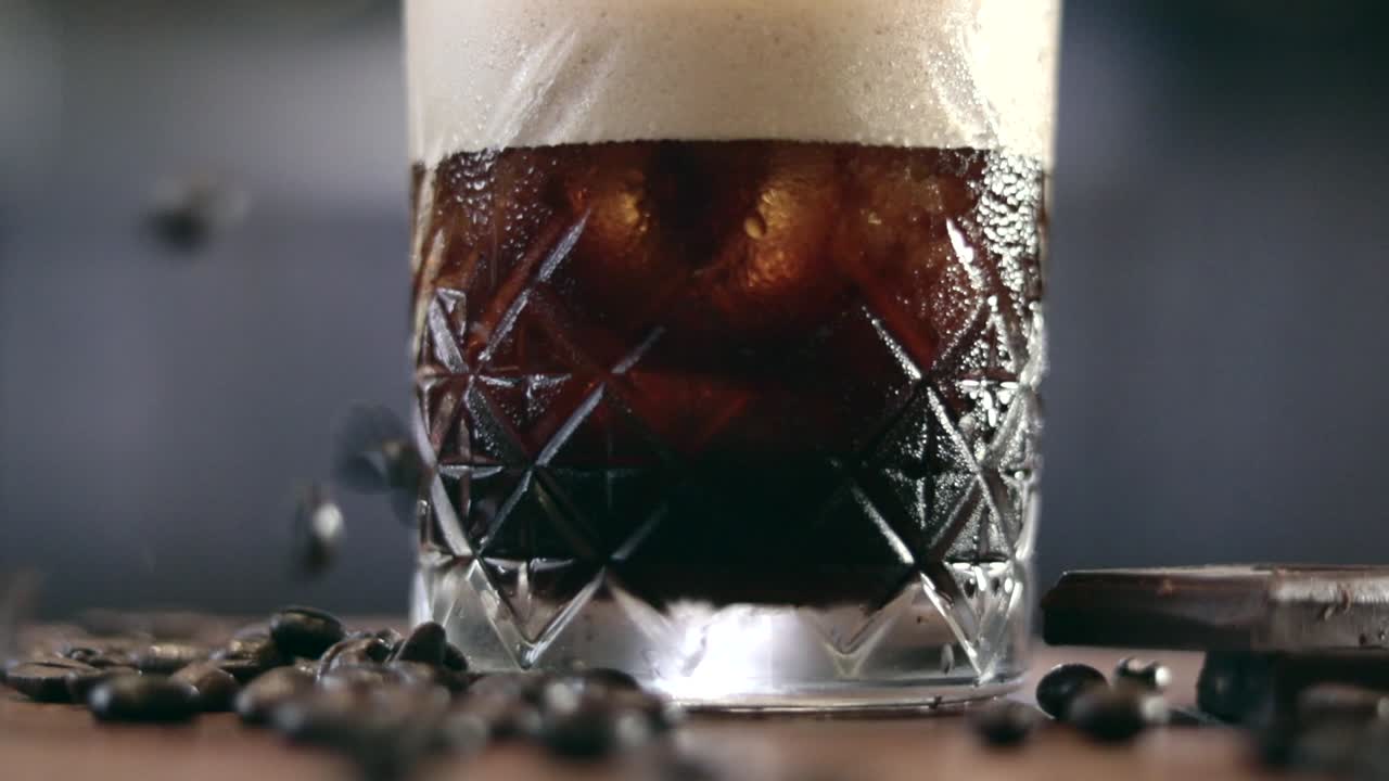 에스프레소 마티니 앞에 떨어지는 커피 원두의 초점 샷