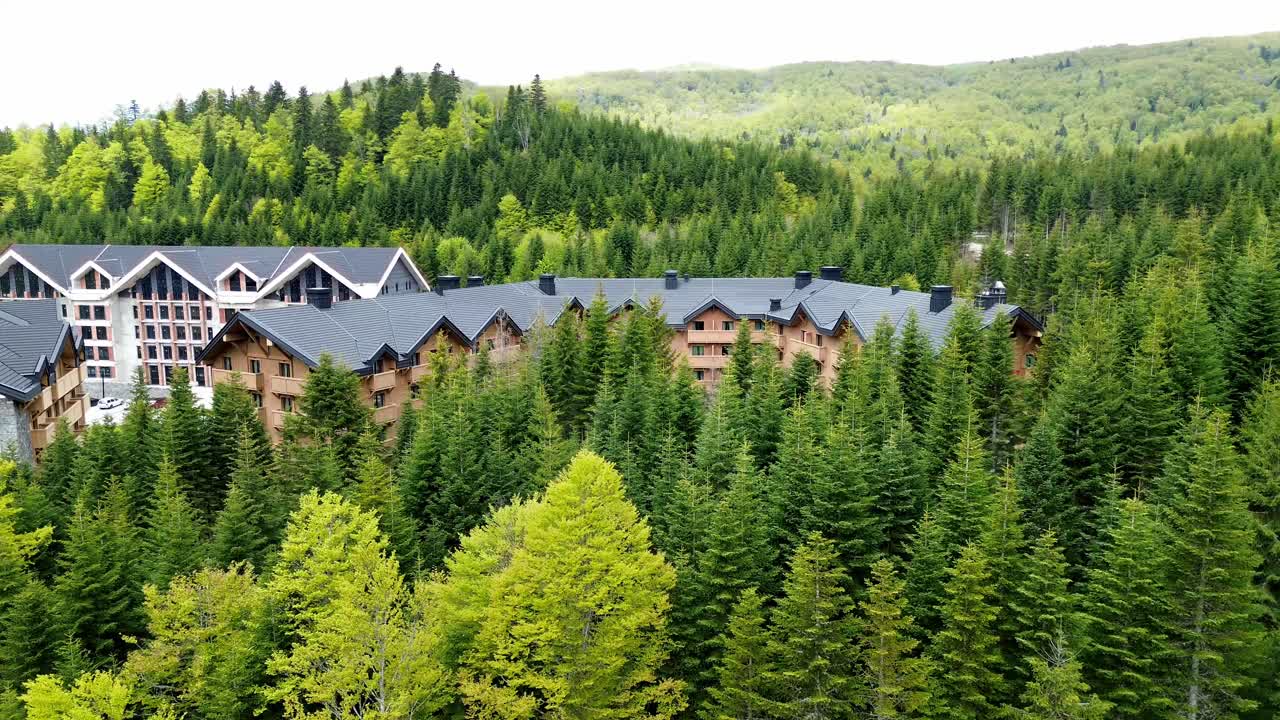 Luxury ski resort in Kolasin valley surrounded by lush pine forest in summer near Biogradska Gora National Park, Swissotel resort, Drone shot