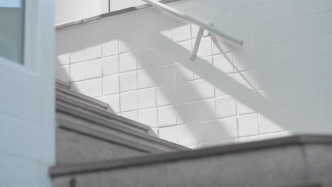 perfect background calm meditation yoga background abstract brick wall white in shopping mall concrete stairway stairs case up to next floor painted white sun shining shadows down tripod steady bricks