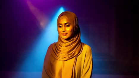 woman in hijab under colorful studio lighting