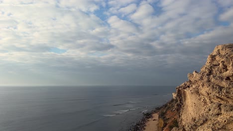 time-lapse of waves rolling into a rugged coastline as seen from a rocky cliff