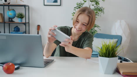 boy using smartphone at desk