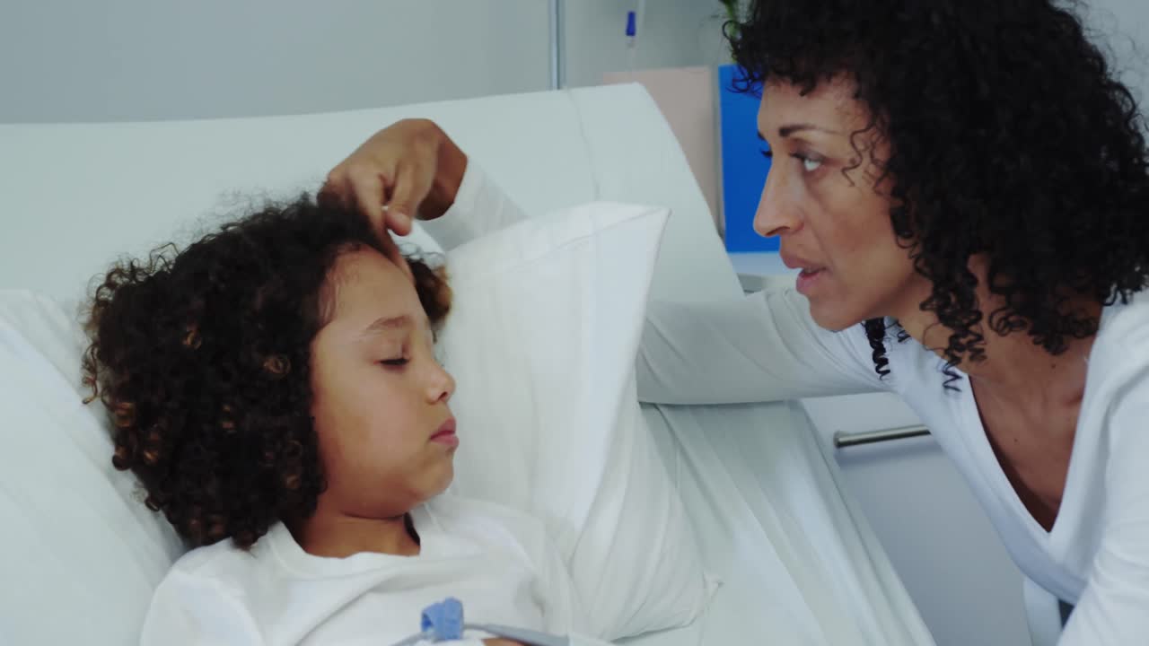 Front view of African american mother talking with her son in ward at hospital 4k