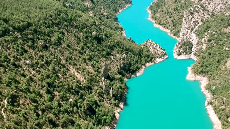 hill slides with water flowing between the ridges of spain valley, drone over the river, green forest cover in spain taken from drone mavic 2 air