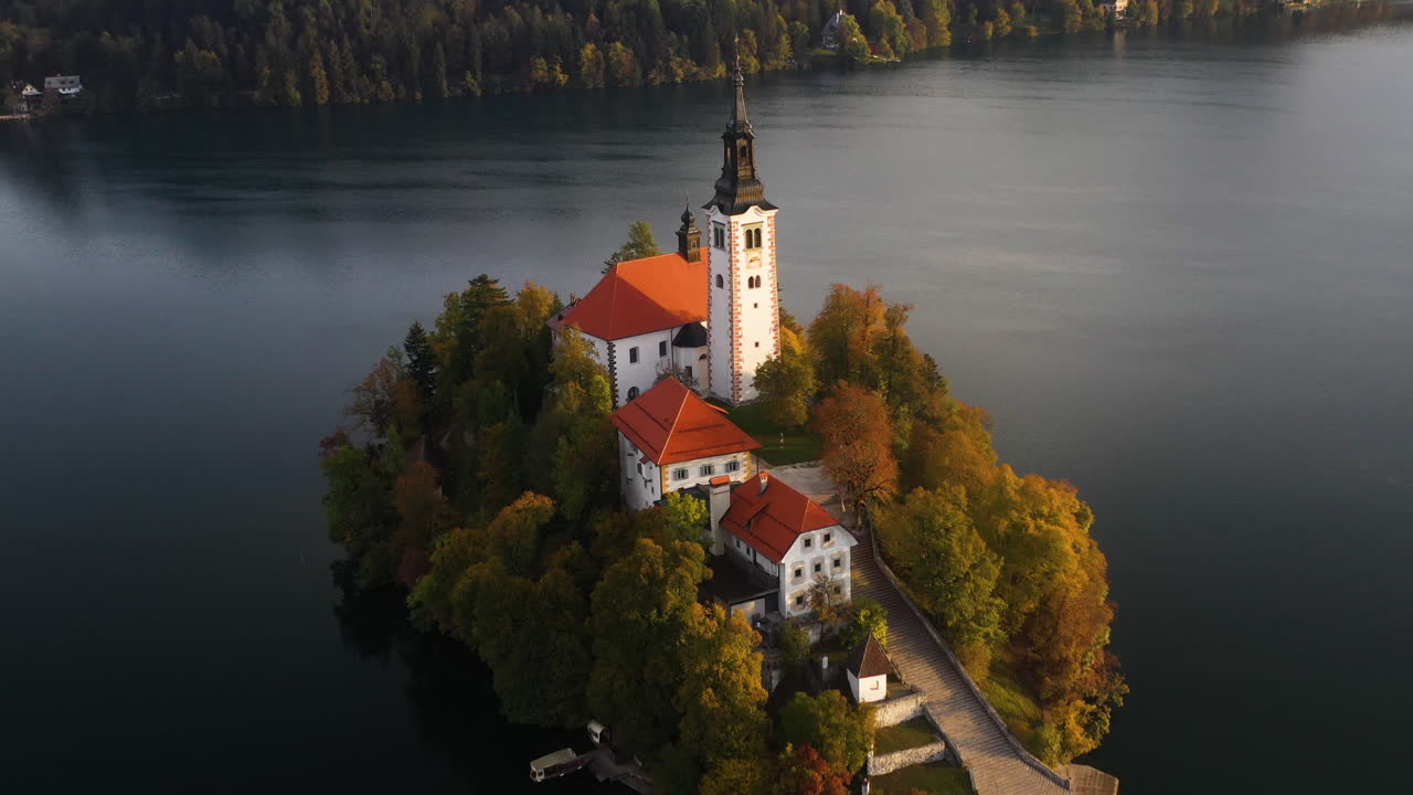 Ripresa con drone rivelatrice della Chiesa della Peregrinazione dell'Assunzione di Maria, Slovenia durante l'ora d'oro