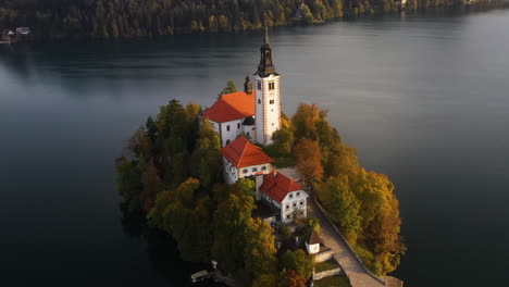 Aufschlussreiche-Drohnenaufnahme-Der-Wallfahrtskirche-Mariä-Himmelfahrt,-Slowenien-Während-Der-Goldenen-Stunde