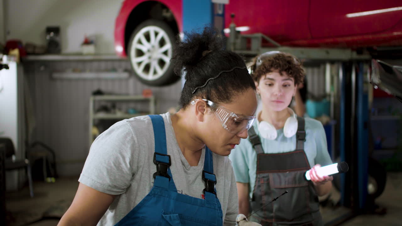 mujeres inspeccionando automóviles