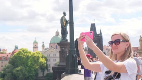 tourist taking a selfie on charles bridge in prague