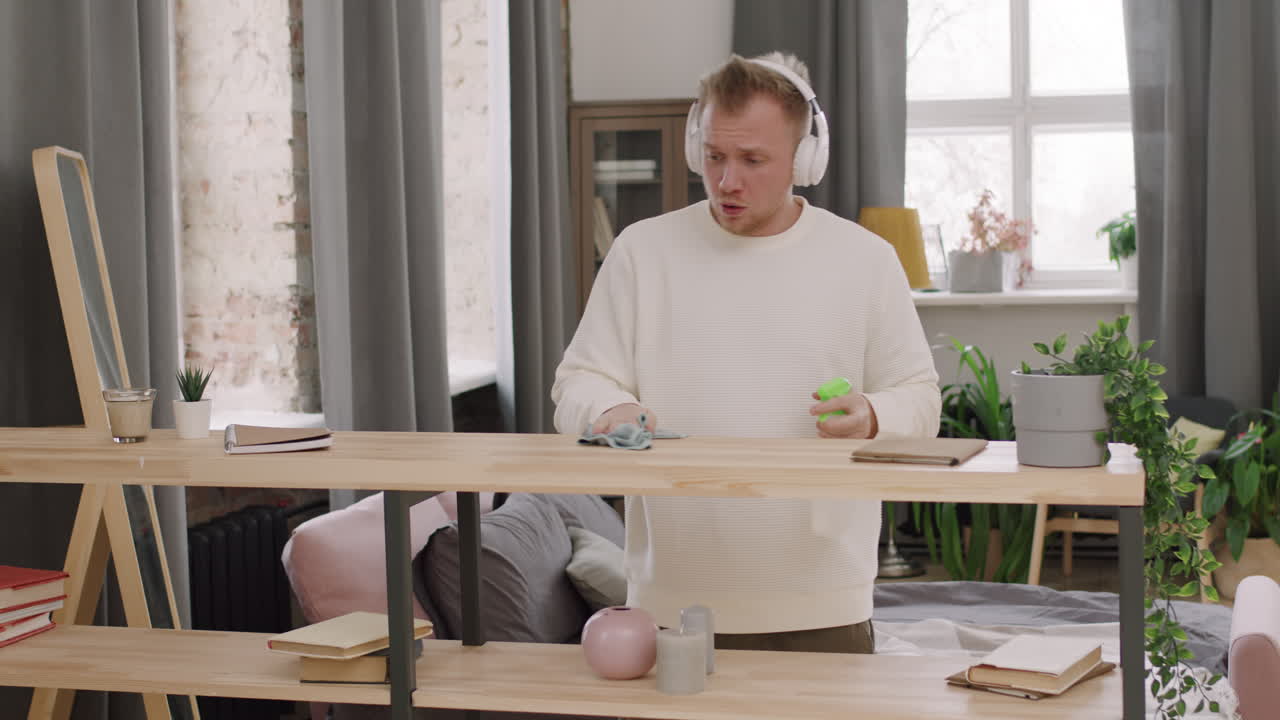 Handsome Man in Headphones Cleaning and Dancing