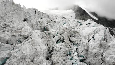 sobrevuelo aéreo a través de las grietas del glaciar moiry cerca de grimenz en valais, suiza con una vista panorámica desde los picos de las montañas hasta el hielo en una tarde nublada de verano
