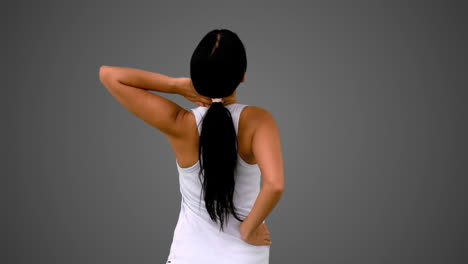 bruneta en forma estirando su espalda y cuello