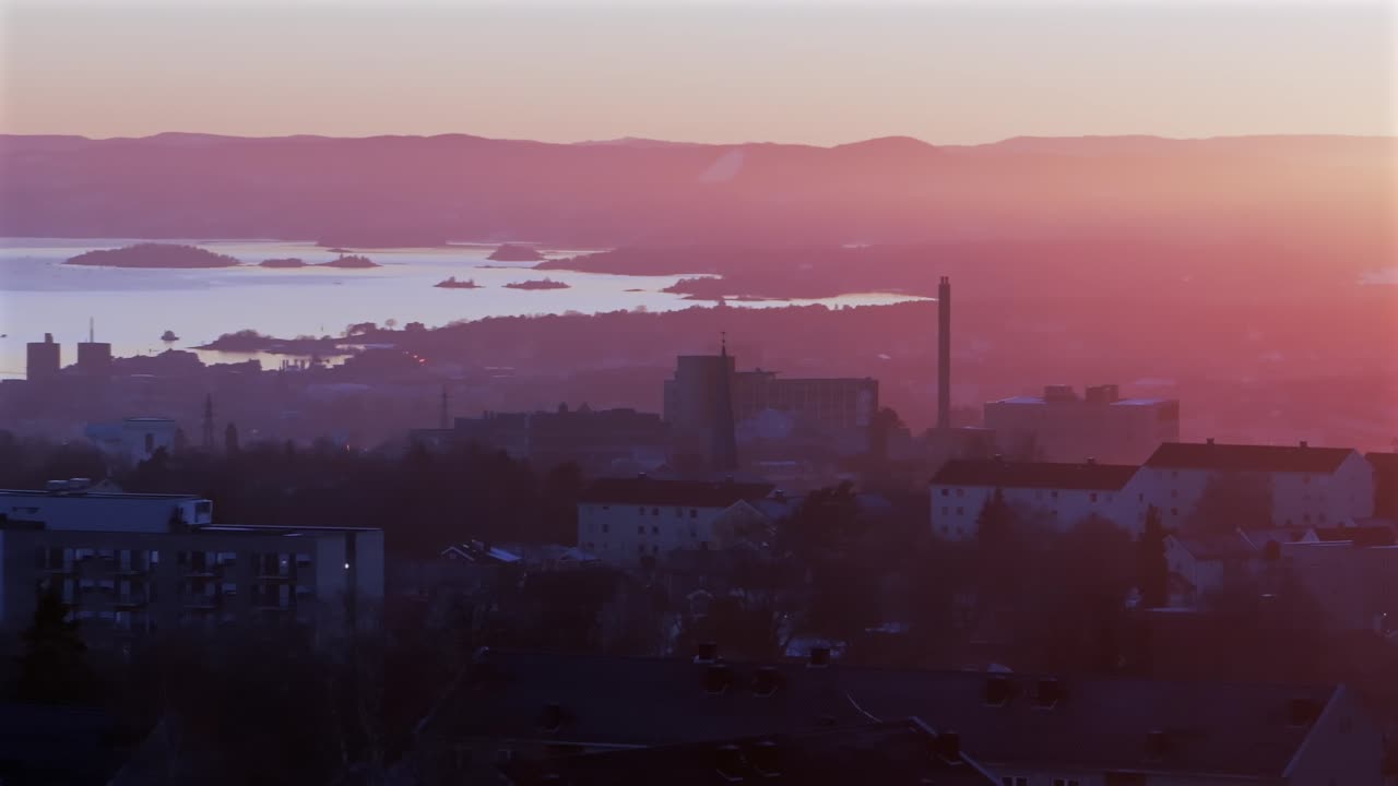 Oslofjord Olso city downtown Norway Norge aerial drone view inner coastline Hovedøya Lindøya islands Norwegian arctic vibrant pink purple hue sunset apartment buildings cityscape parallax circle right