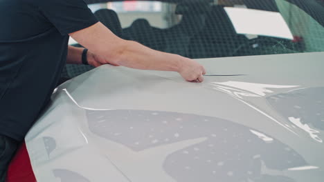 Protective film on hood of car. Close up of pasting protective film of the automobile