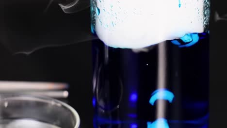el hielo seco reacciona en el vaso líquido azul