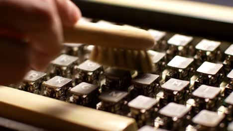 cleansing the vintage typewriter keys: a close-up focus on cleaning the metallic keyboard of a classic typewriter for preservation and maintenance