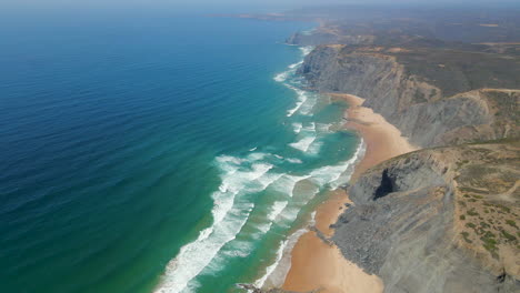 Vista-Aérea-De-La-Costa-Vicentina-Con-Acantilados-Junto-A-La-Playa-En-Un-Día-Soleado-De-Verano,-Algarve,-Portugal