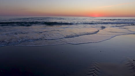 4k low pan aerial shot of the sea coast at dusk