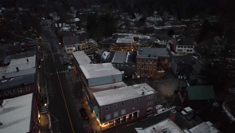 early morning rising aerial, town of woodstock, vermont with cars passing by on cold winter day