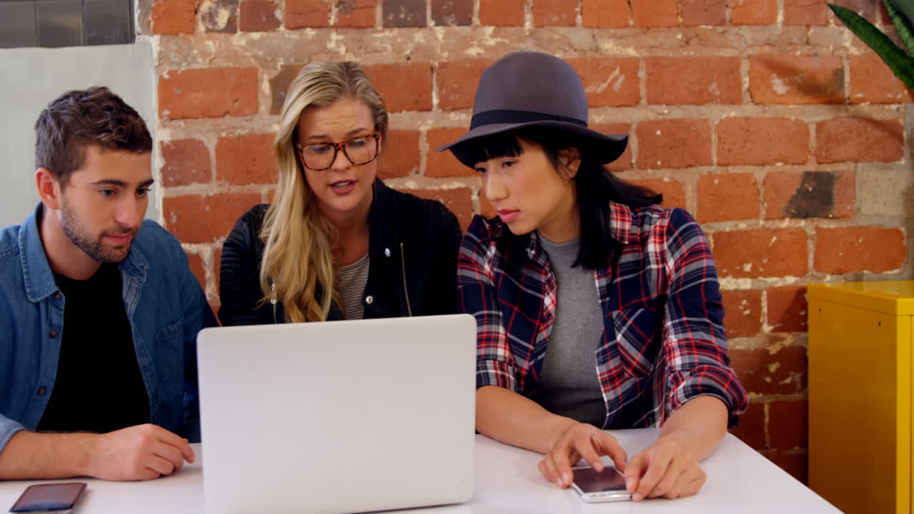 ejecutivos discutiendo sobre una computadora portátil 4k