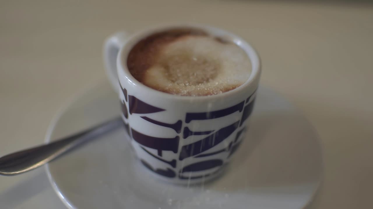 azúcar moreno cayendo en una taza de café espresso