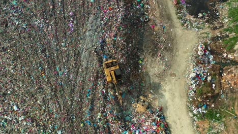 aerial top down view, drone flyover massive sanitary landfill with sprawling unsorted solid waste piles, environmental sustainability concerns and the impact of global warming and climate change