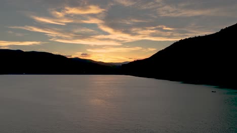 Cloudscape-Dorado-Del-Atardecer-Sobre-Un-Lago-De-Montaña-En-Silueta---Hiperlapso-Aéreo-Deslizante