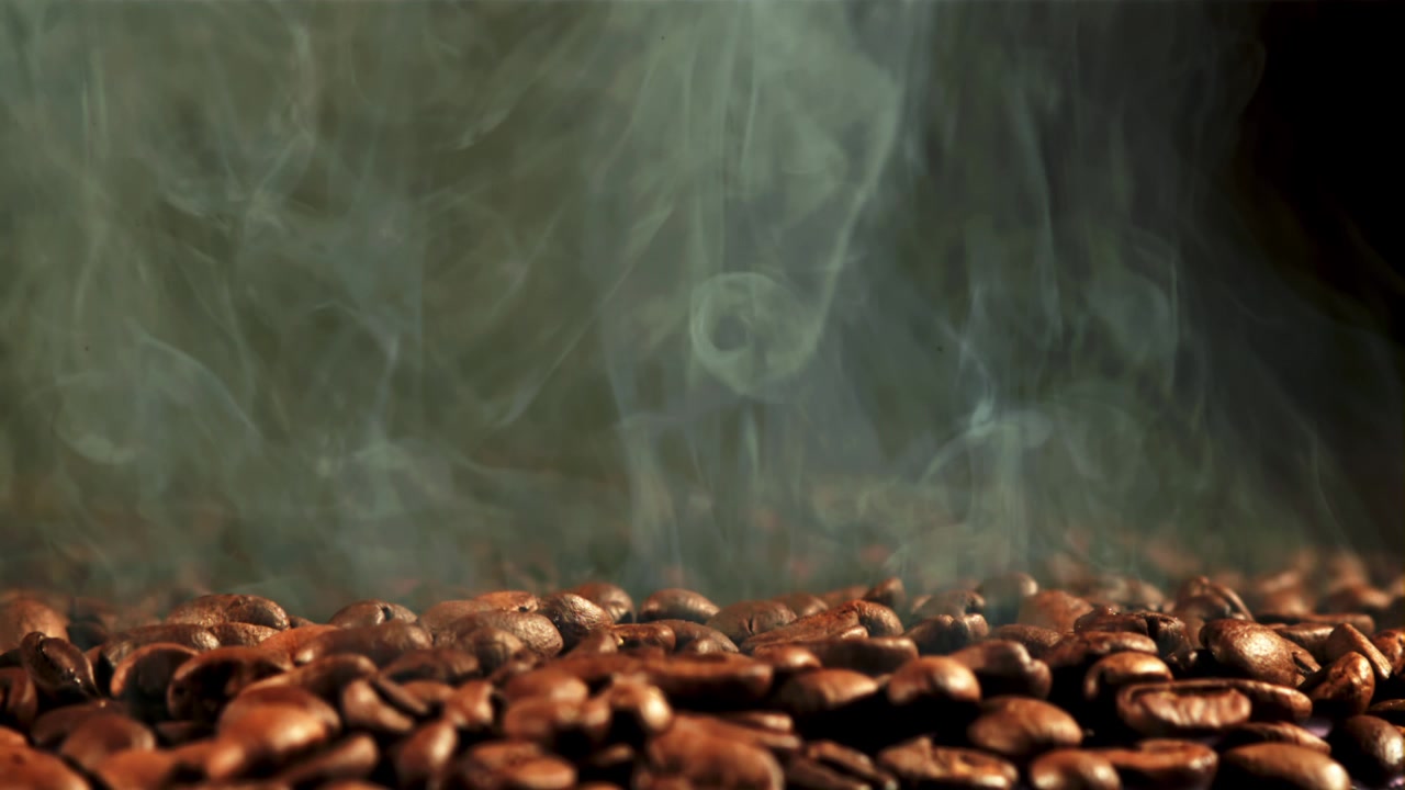 Chicchi di caffè appena tostati con vapore e fumo che salgono