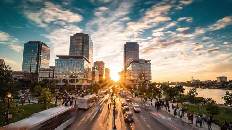 Vedute di tramonti urbani che mostrano strade trafficate con sagome di pedoni e architettura moderna che riflette cieli vibranti in una vivace area metropolitana.