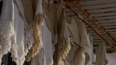 Ponchos-hanging-in-the-seaside-town-of-Nazare,-Portugal