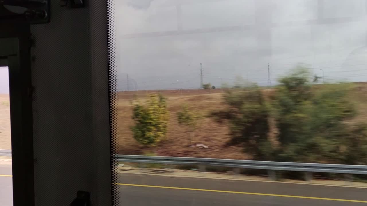 Una vista dalla finestra di una strada con un campo sullo sfondo.